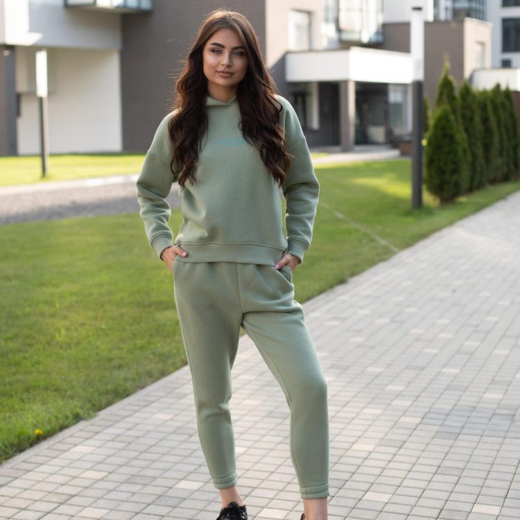 stock-photo-fashion-young-model-with-long-wavy-hair-wearing-stylish-sweatshirt-joggers-with-black-leather-shoes-standing-modern-street-with-contemporary-buildings-min