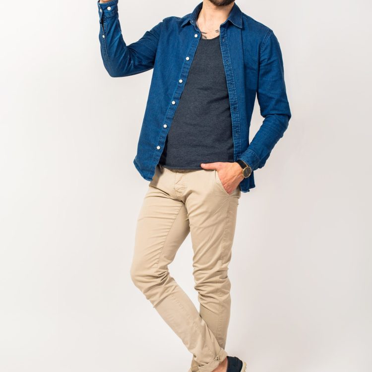 young-handsome-hipster-man-trendy-style-outfit-denim-shirt-trousers-sunglasses-hat-isolated-jumping-cheerful-pointing-finger-min